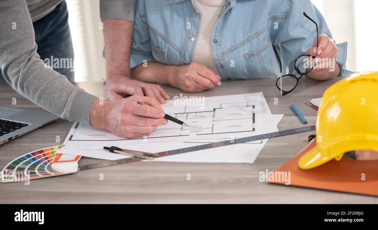Architects working on blueprint of new construction project Stock Photo
