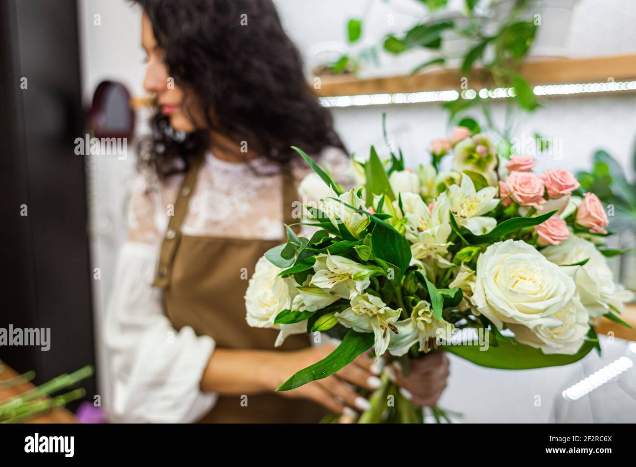 Attractive young woman florist is working in a flower shop Stock Photo ...