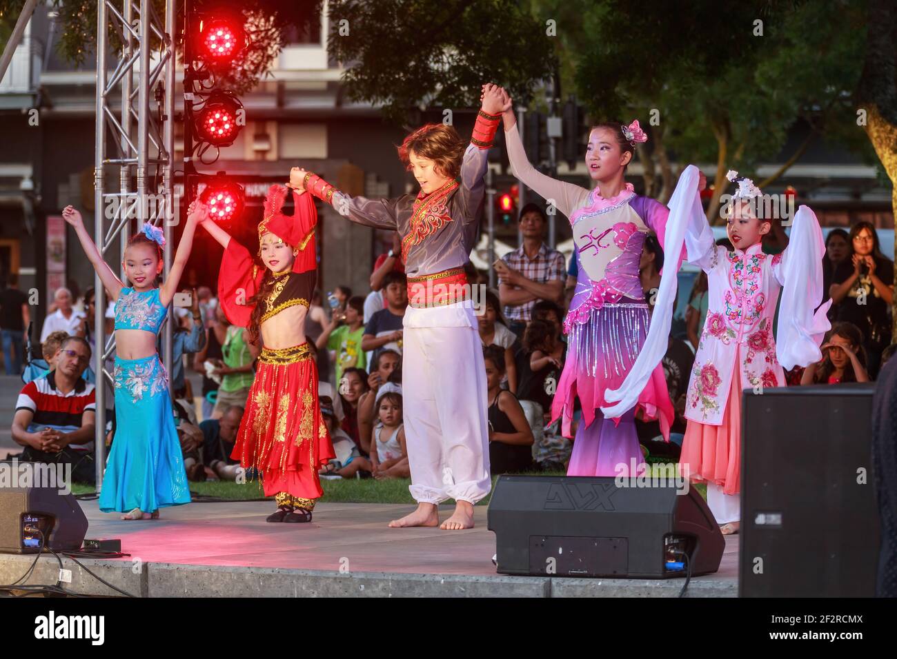 Children in the clothing of various Chinese ethnic groups on stage during Chinese New Year celebrations. Hamilton, New Zealand Stock Photo