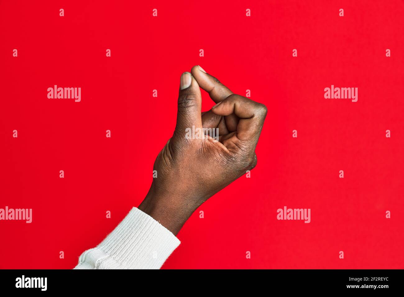 Arm and hand of african american black young man over red isolated