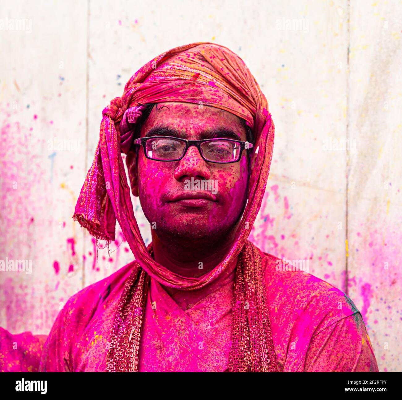 portrait of a boy celebrating holi at barsana on holi festival with selective focus on subject and added noise and grains. Stock Photo