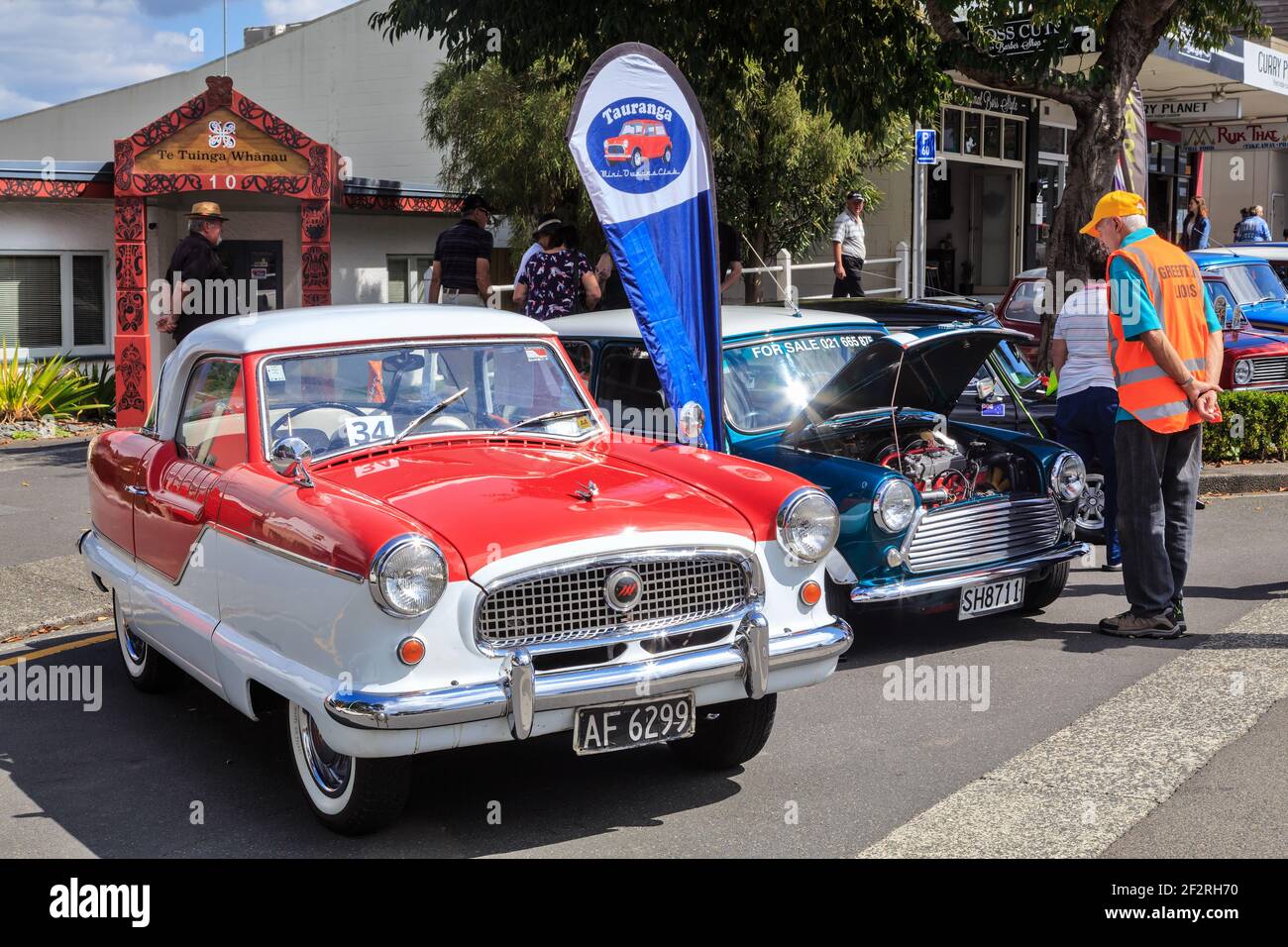 A pair of classic cars, a 1958 Austin Metropolitan and a 1981 Morris Mini, side by side at an outdoor car show Stock Photo