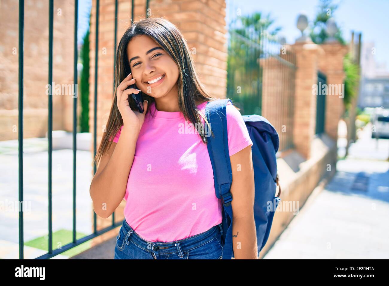 Young latin student girl smiling happy talking on the smartphone at ...