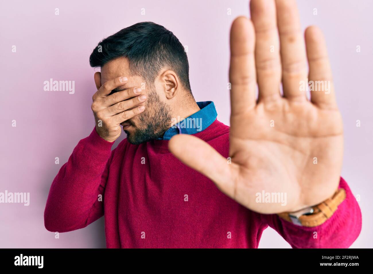 Young hispanic man wearing casual clothes covering eyes with hands and ...