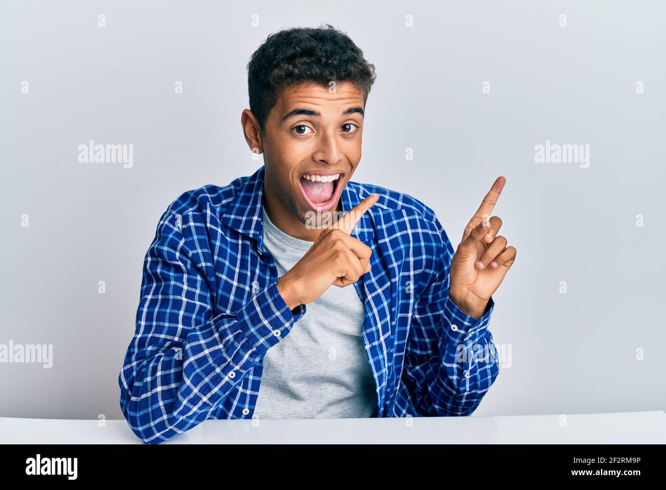 Young handsome african american man wearing casual clothes sitting on ...
