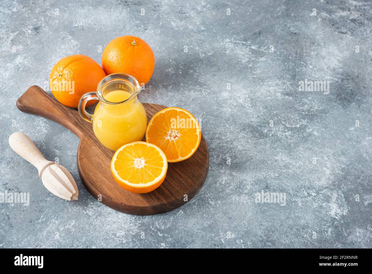 A wooden board full of juicy slices of orange fruit on stone background Stock Photo