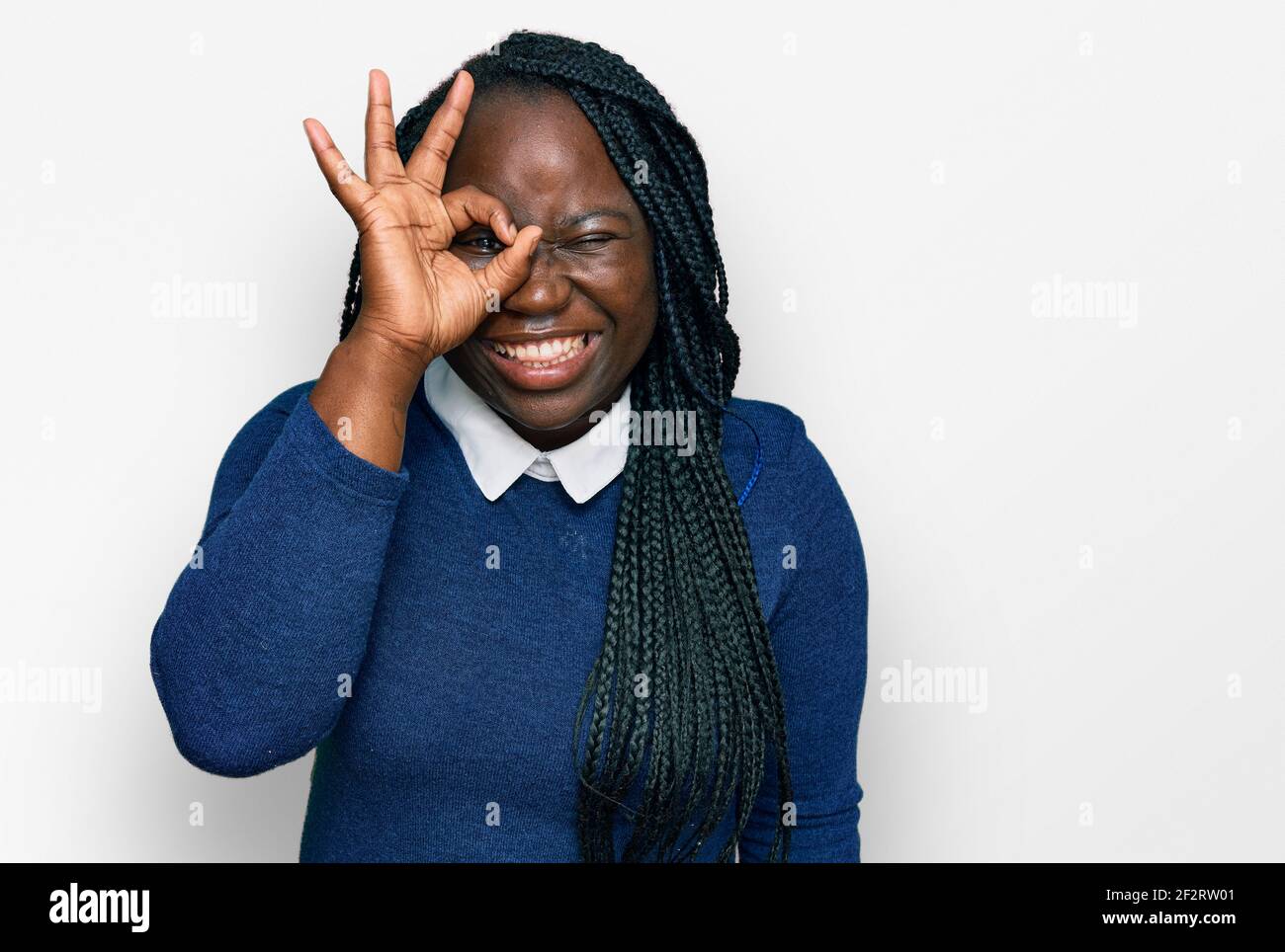 Young black woman with braids wearing casual clothes doing ok gesture ...