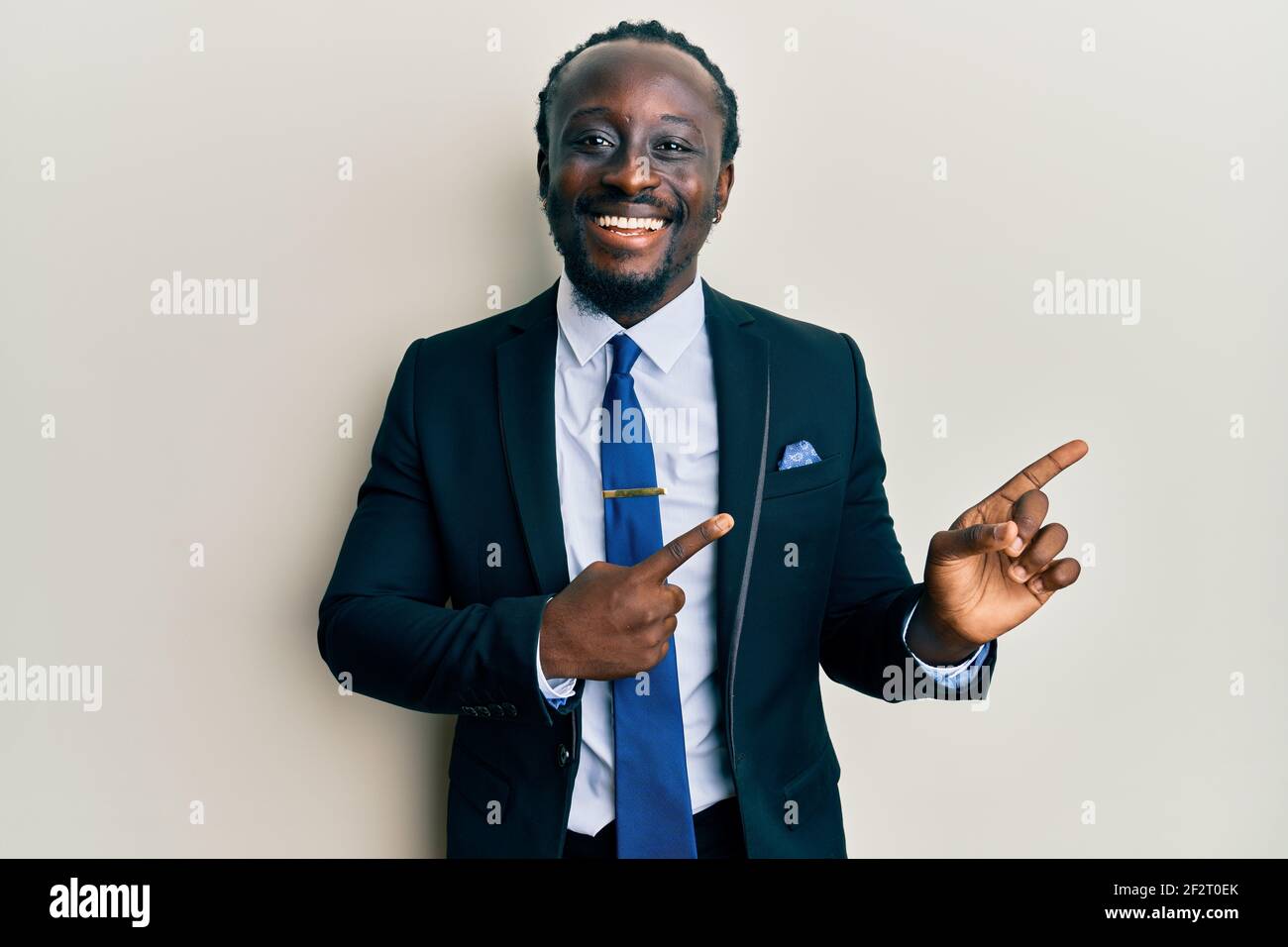 Handsome young black man wearing business suit and tie smiling and ...