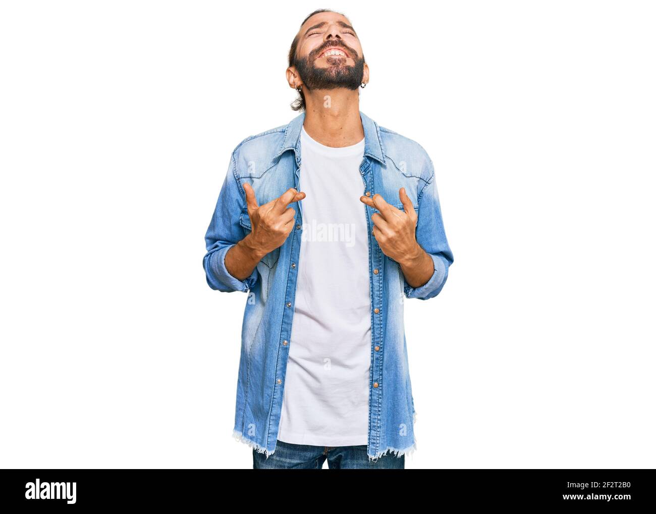 Attractive man with long hair and beard wearing casual denim jacket ...