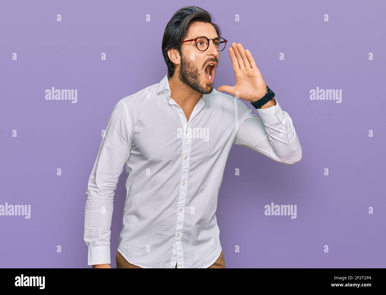 Young hispanic man wearing business shirt and glasses shouting and ...