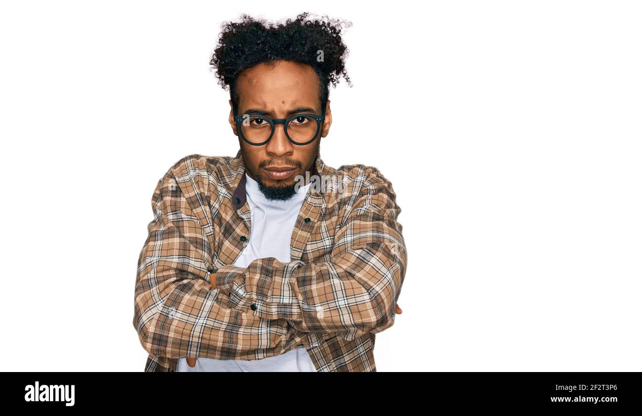 Young african american man with beard wearing casual clothes and glasses skeptic and nervous, disapproving expression on face with crossed arms. negat Stock Photo
