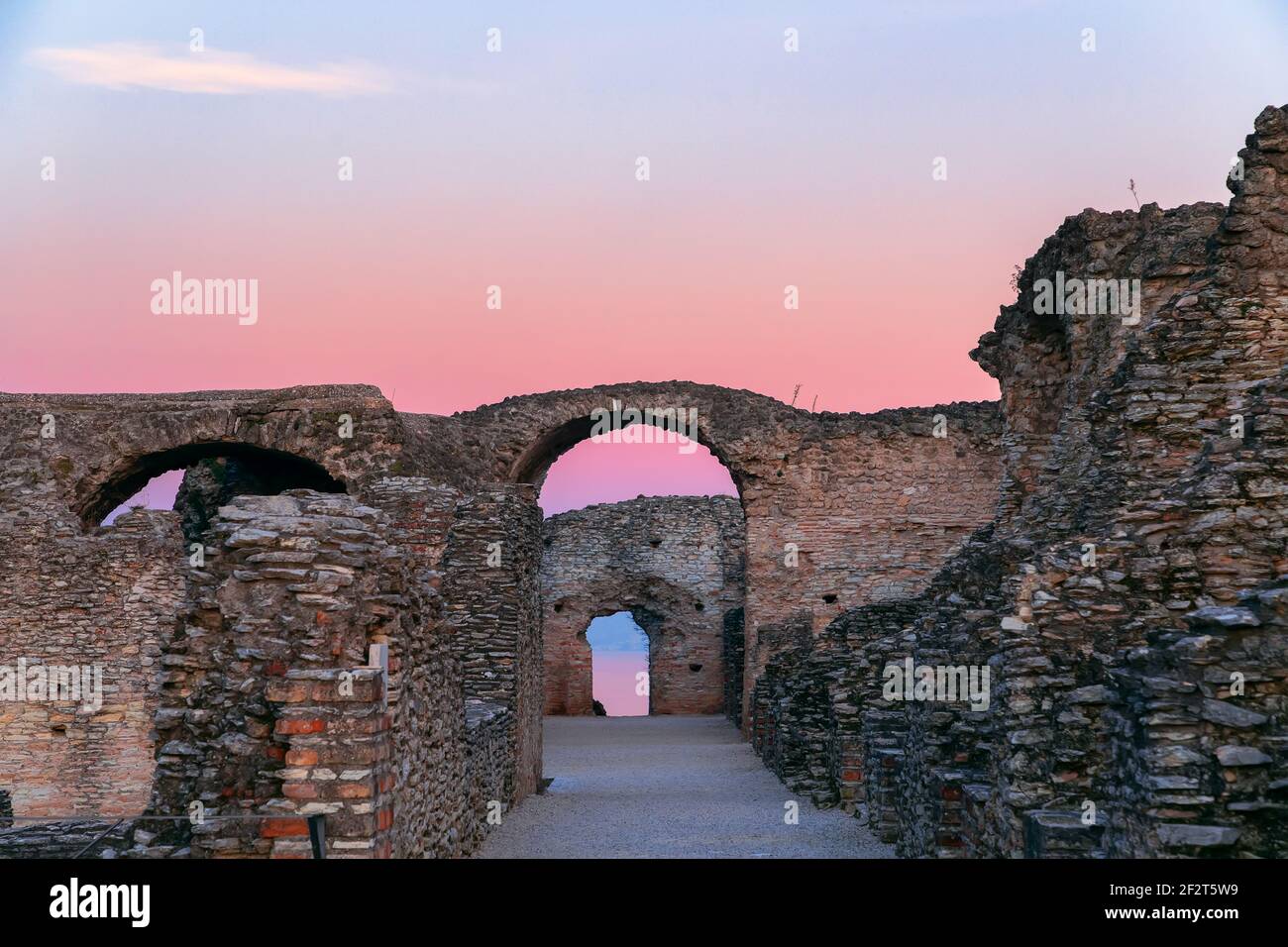 Scenic ruins in the rays of sunset of Grottoes of Catullus, roman villa in Sirmione city, Lake Garda, Italy. Winter time. Stock Photo