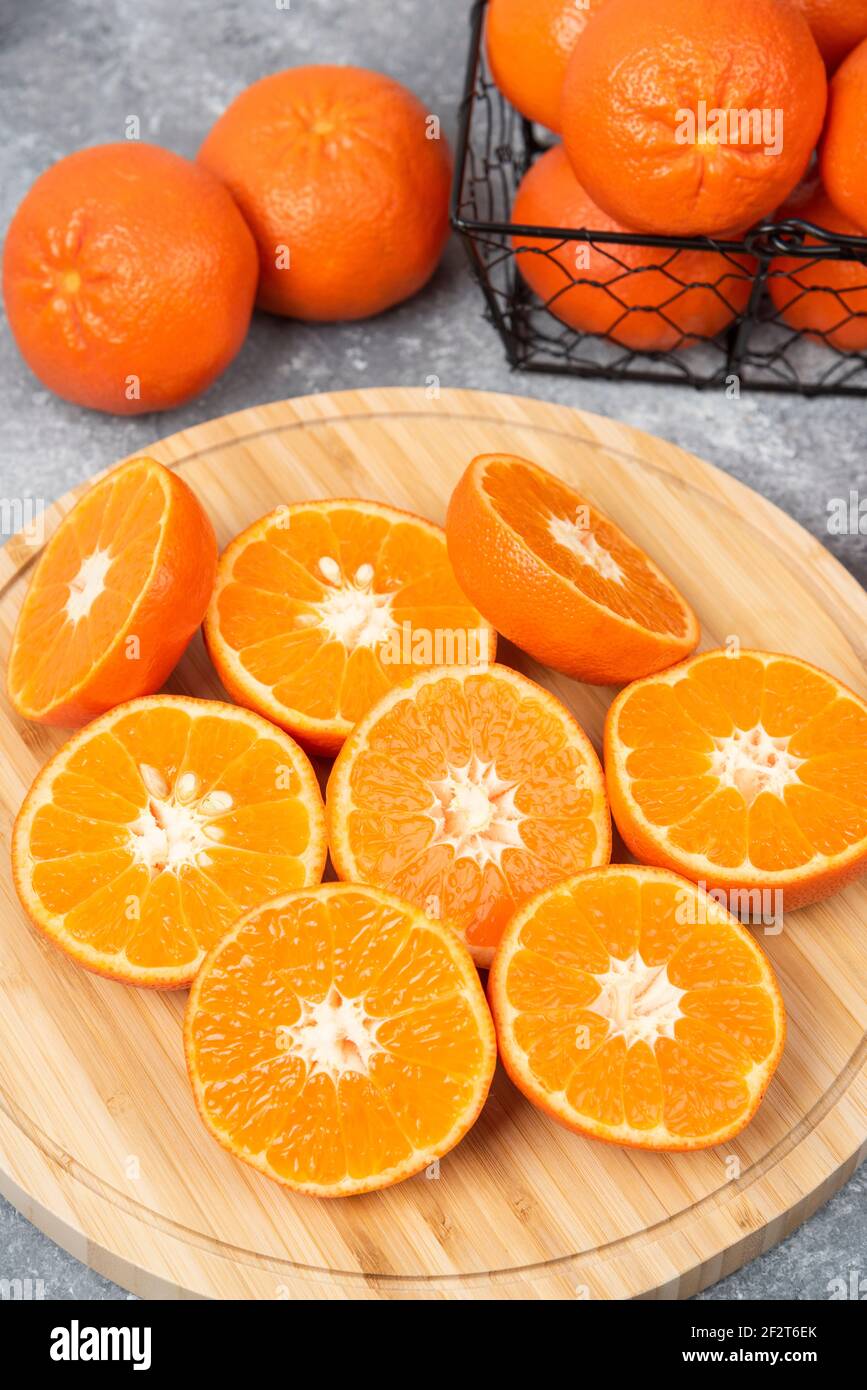 Sliced and whole juicy fresh orange fruits placed on a stone background Stock Photo
