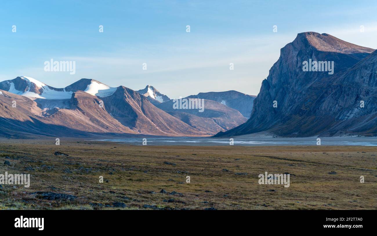 Monumental, wild arctic valley during sunset. Tall peaks with snow on ...