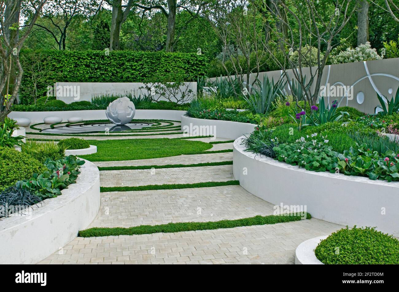 Modern water garden with sculpture feature and raised beds Stock Photo