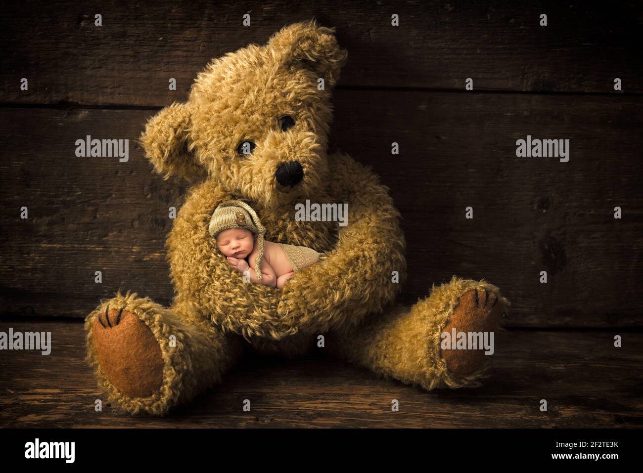 Old teddy bear holding sleeping baby boy Stock Photo Alamy