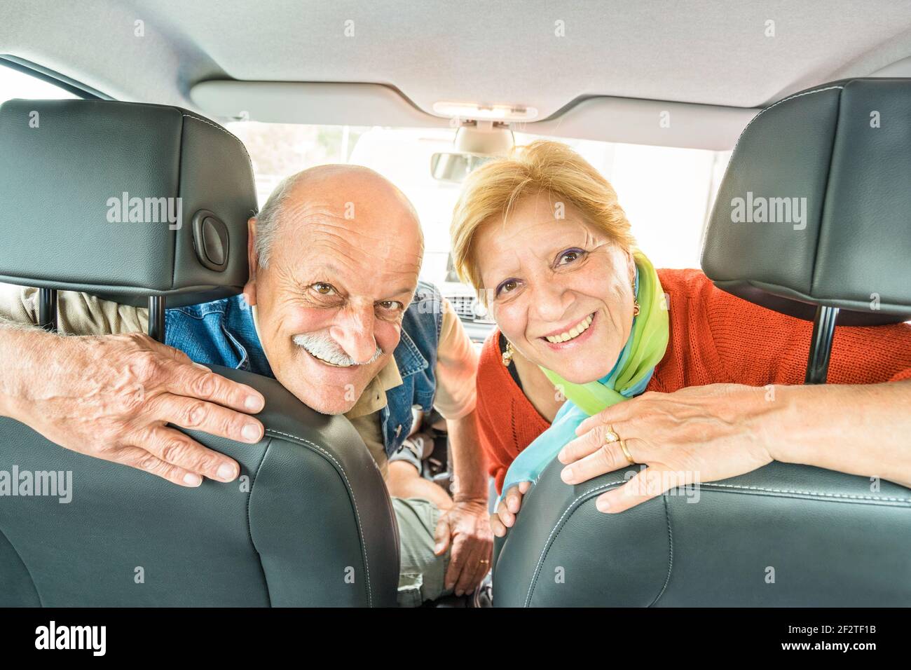 Happy senior couple ready for driving car on journey trip - Concept of joyful active elderly with retired man and woman enjoying their best years Stock Photo