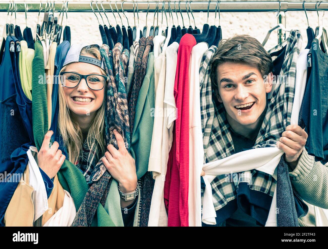 Young hipster couple in love at the weekly cloth market - Best friends sharing free time having fun and shopping in the old town Stock Photo
