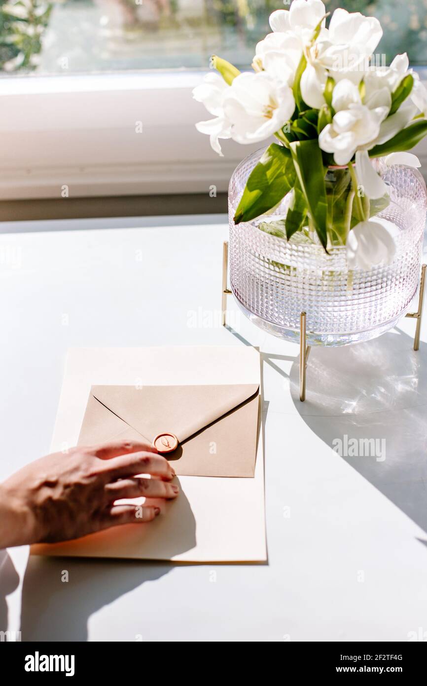 flat lay desk with enveloping and flowers for lifestyle and office for Instagram or digital marketing branding pictures. Stock Photo