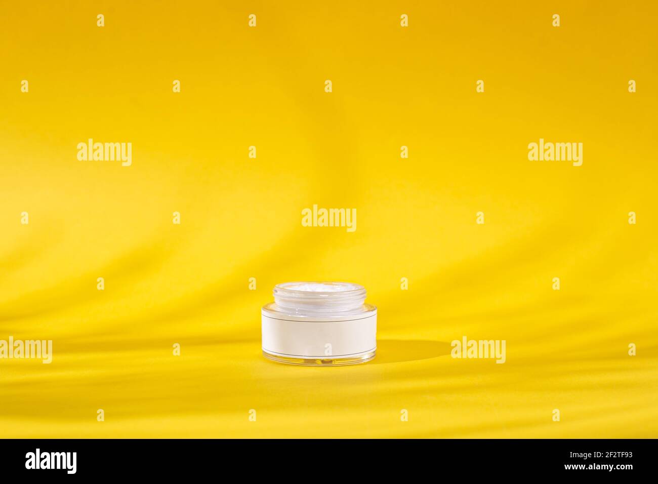 Skin Care Cream jar or bottle in a yellow background with shades, add your own logo or text Stock Photo