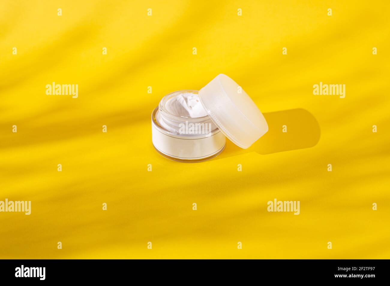 Skin Care Cream jar or bottle in a yellow background with shades, add your own logo or text Stock Photo