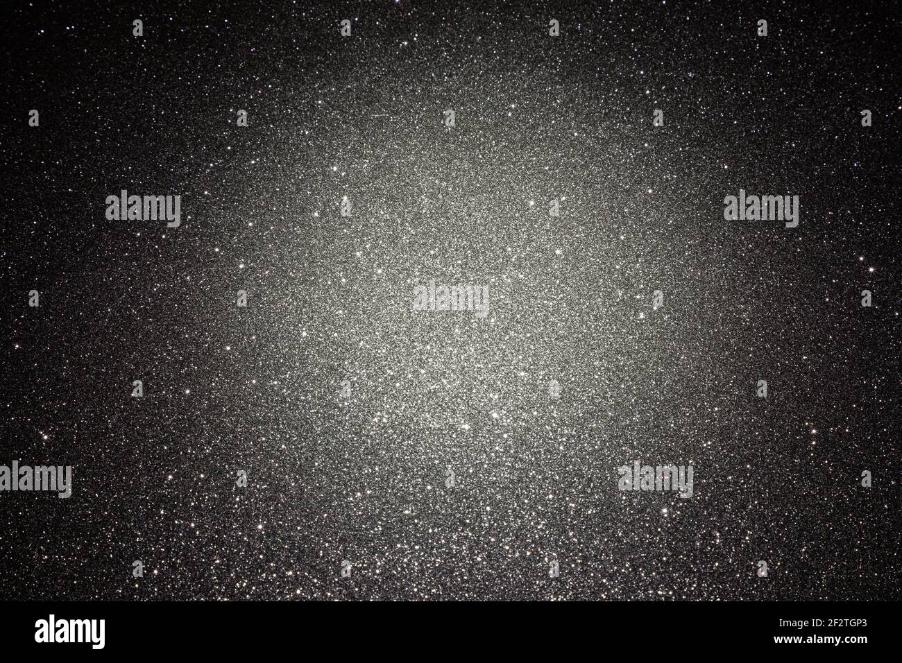 Black texture with micro-relief and glitter. Black glitter texture with illuminated center Stock Photo