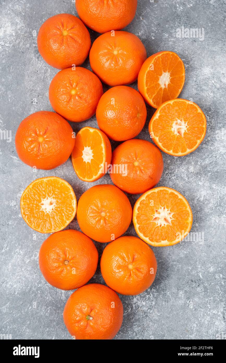 Whole and slice juicy fresh orange fruits placed on a stone background Stock Photo