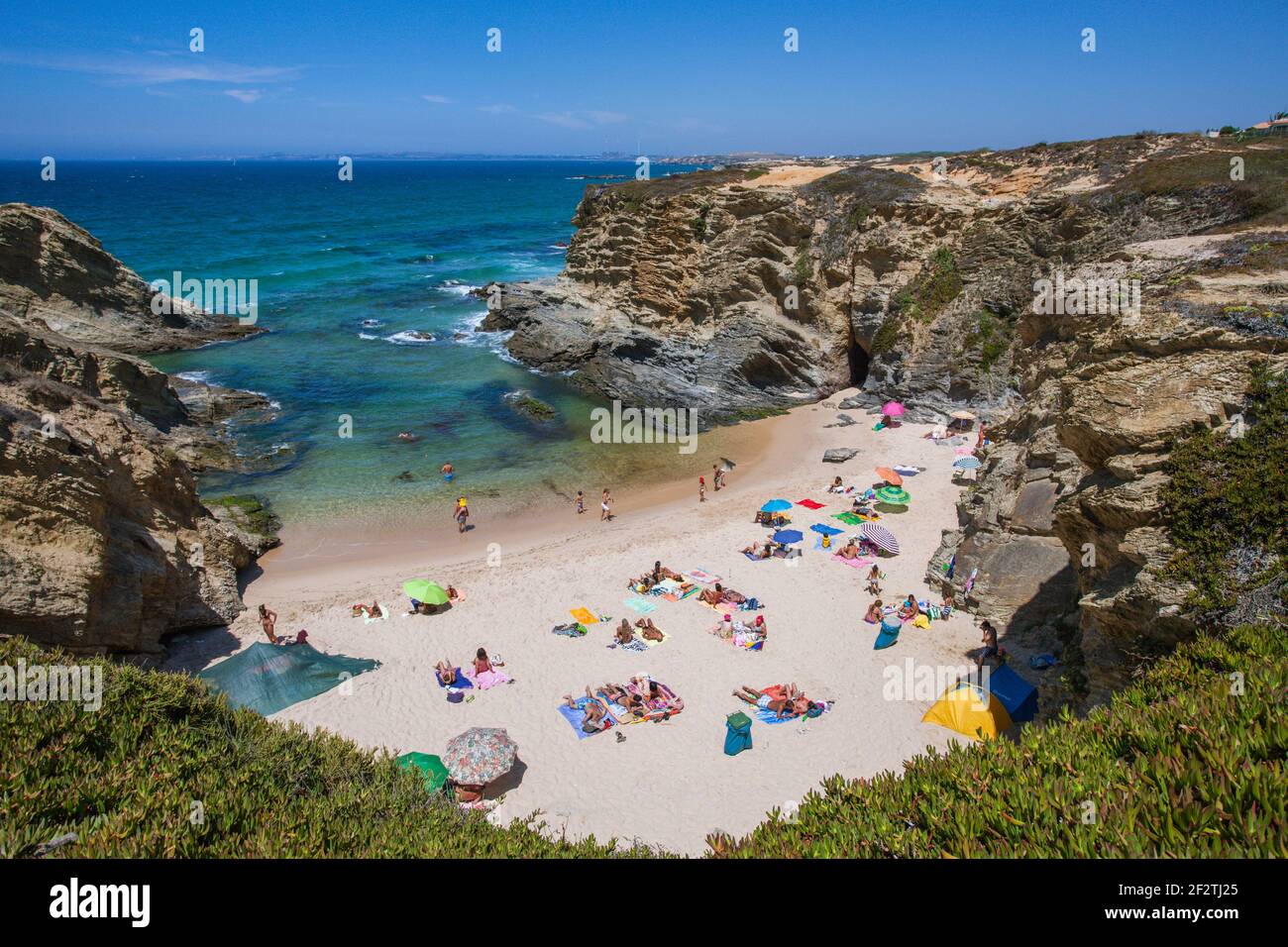 Holidaymakers sunbathing in a secret beach cove, in Porto Covo, Alentejo - Portugal. Stock Photo