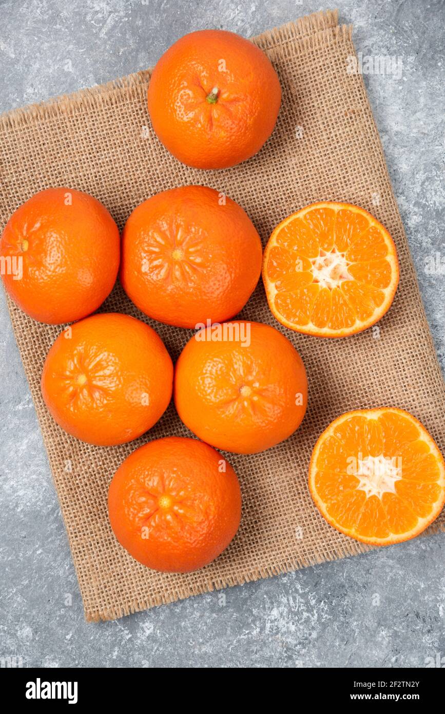 Juicy orange fruits with slices on stone background Stock Photo