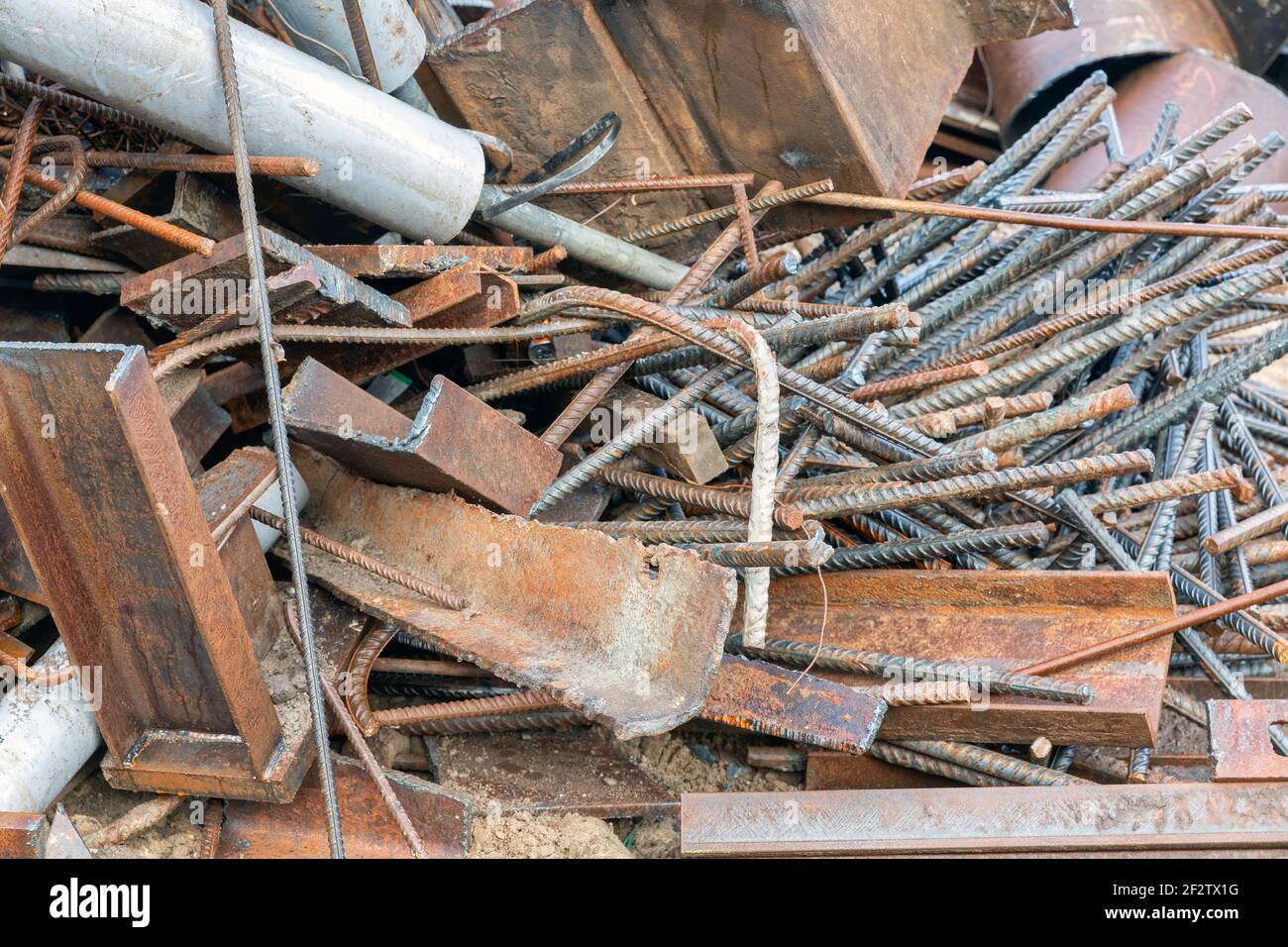 Pile of scrap metal with concrete steel and construction equipment