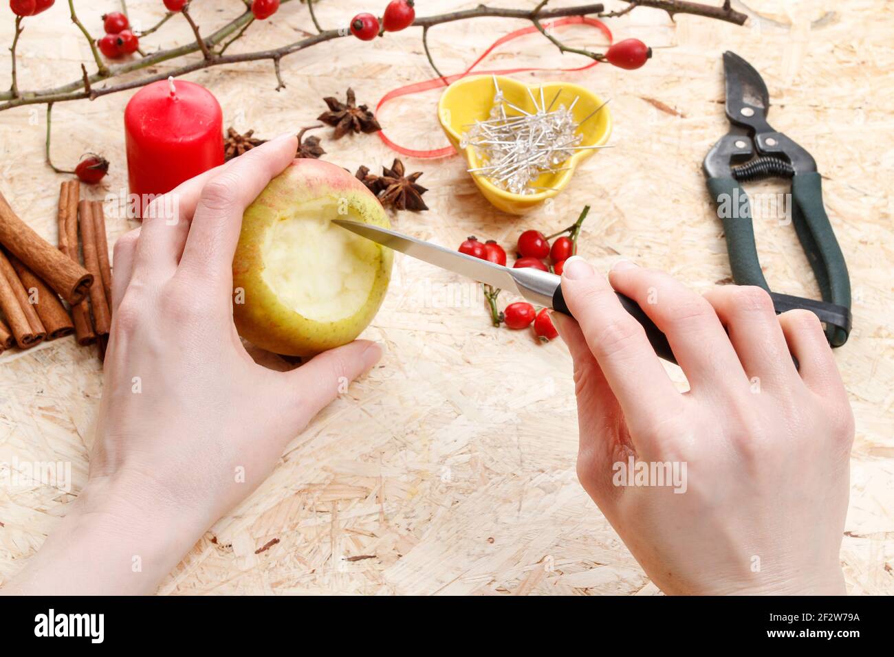 Florist at work: How to make apple and wild rose candle holders, autumn home decor - tutorial. Stock Photo