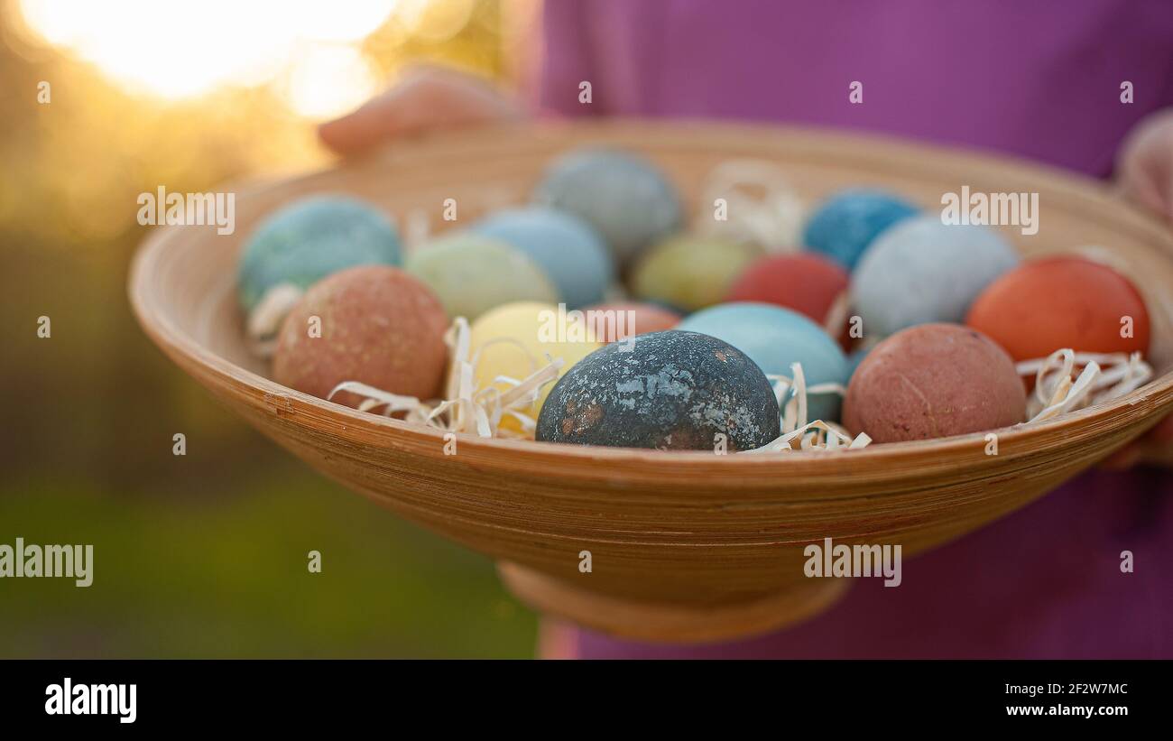 Girl holding a wooden plate with easter eggs Stock Photo