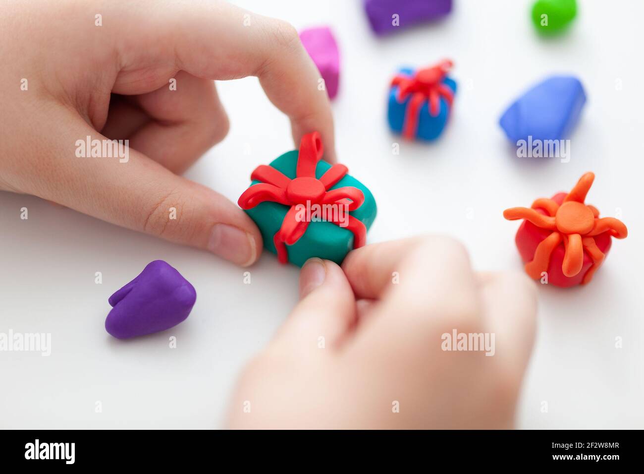 A young boy making polymer clay gift boxes. Shallow depth of field. Close up. Stock Photo