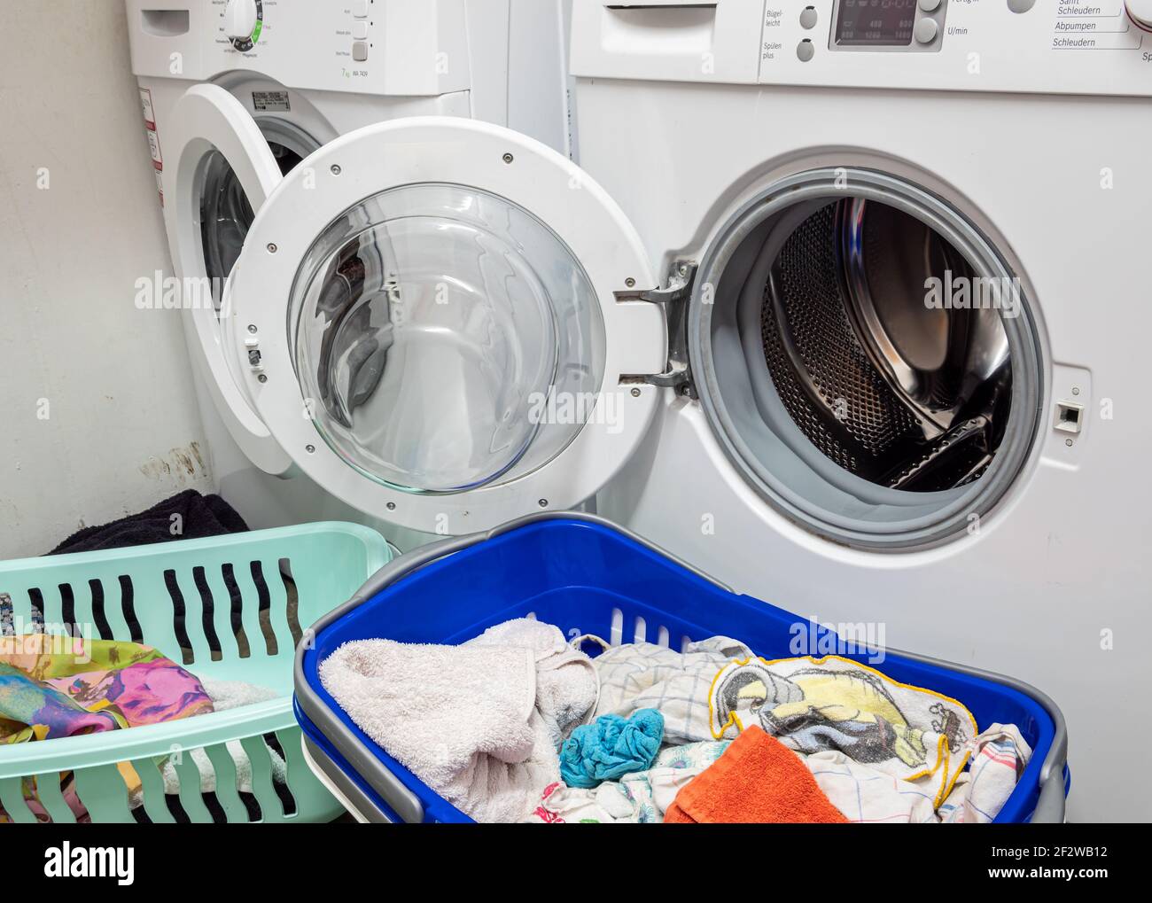 Laundry basket with dirty laundry and washing machine at home Stock Photo