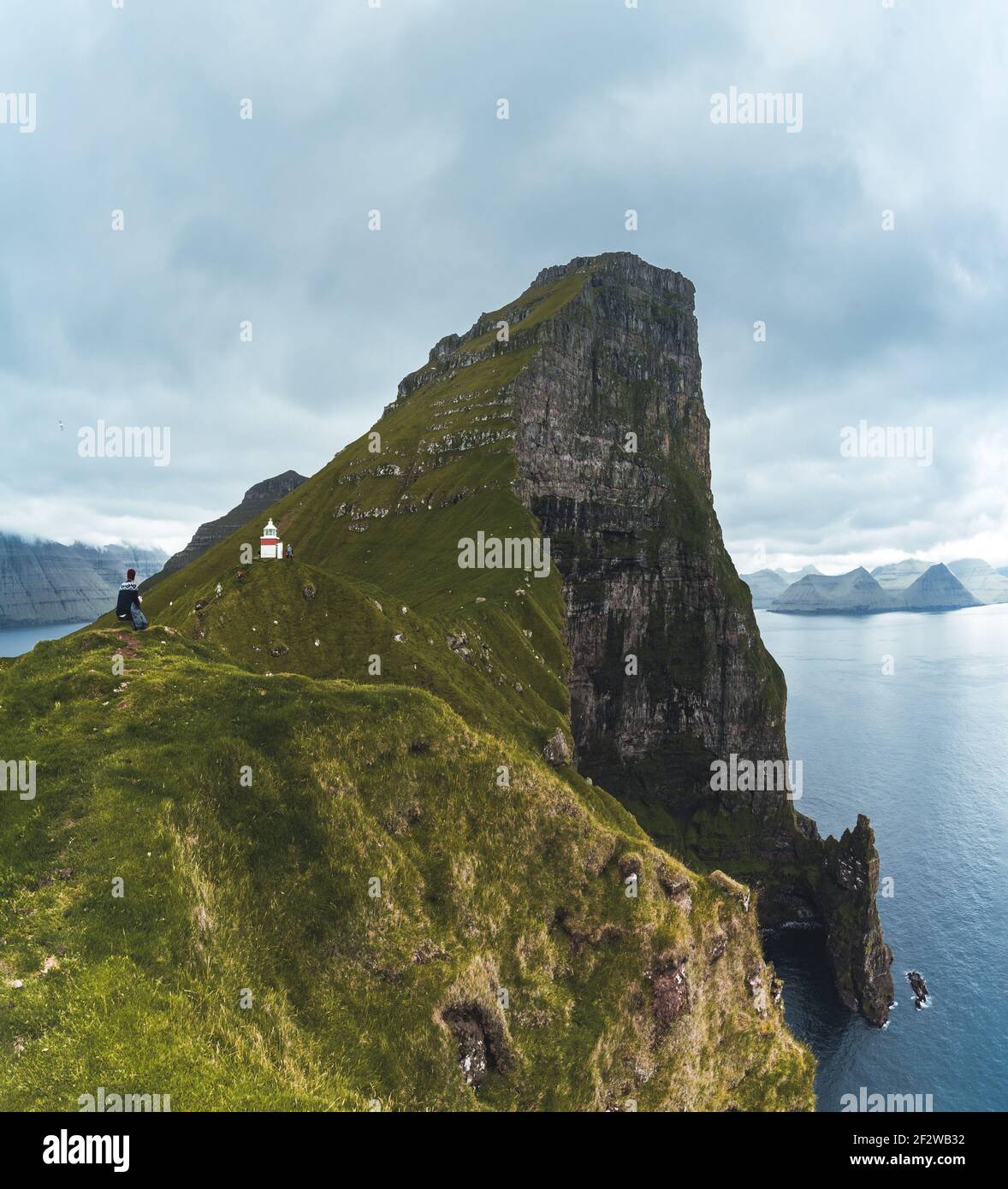 Kalsoy Island with Kallur lighthouse on on Faroe islands, Denmark, Europe. Clouds over high cliffs, turquoise Atlantic ocean and spectacular views. Stock Photo
