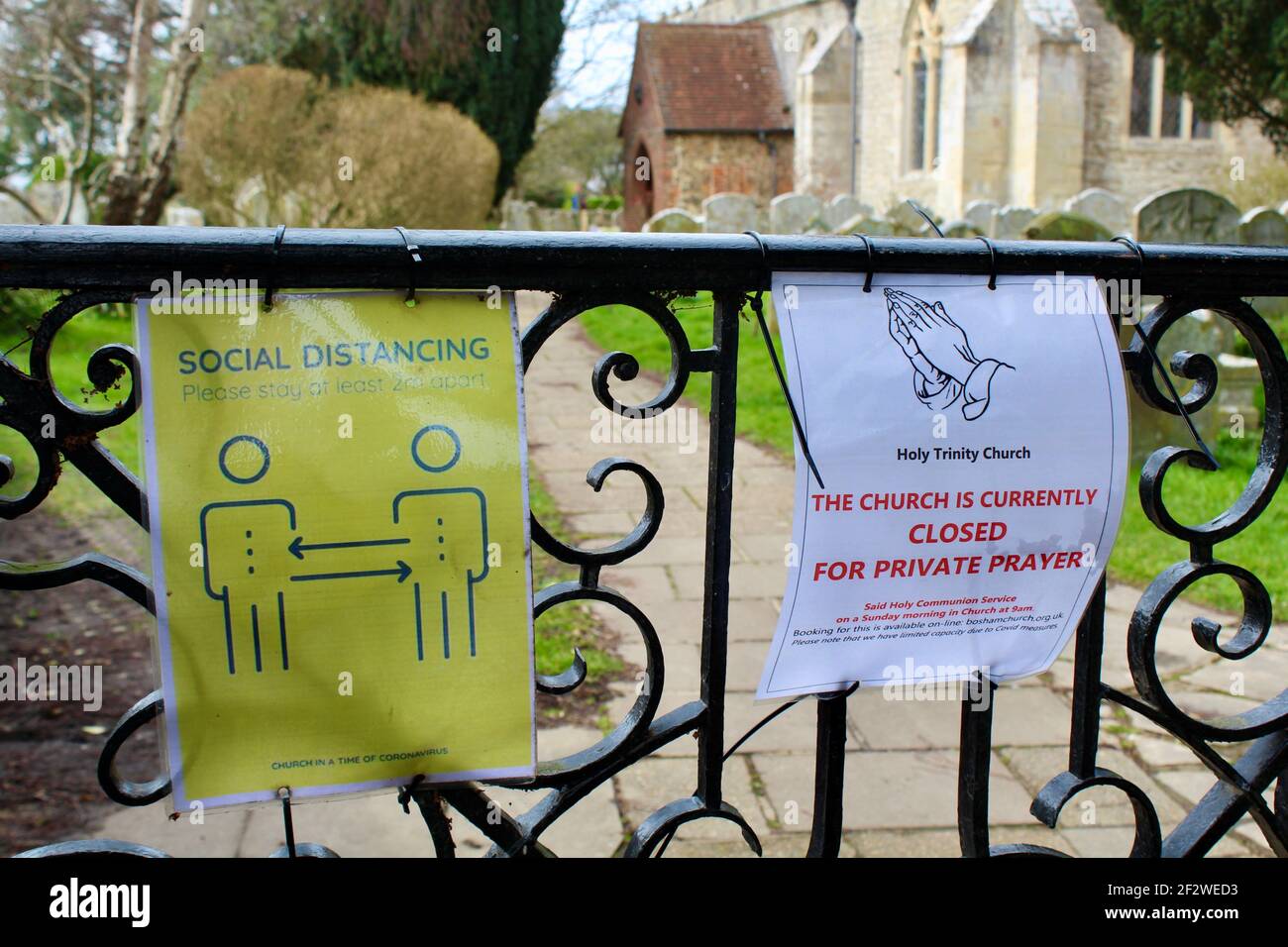Notices on church gate informing that the church is currently closed for private prayer and social distance guidelines. Stock Photo