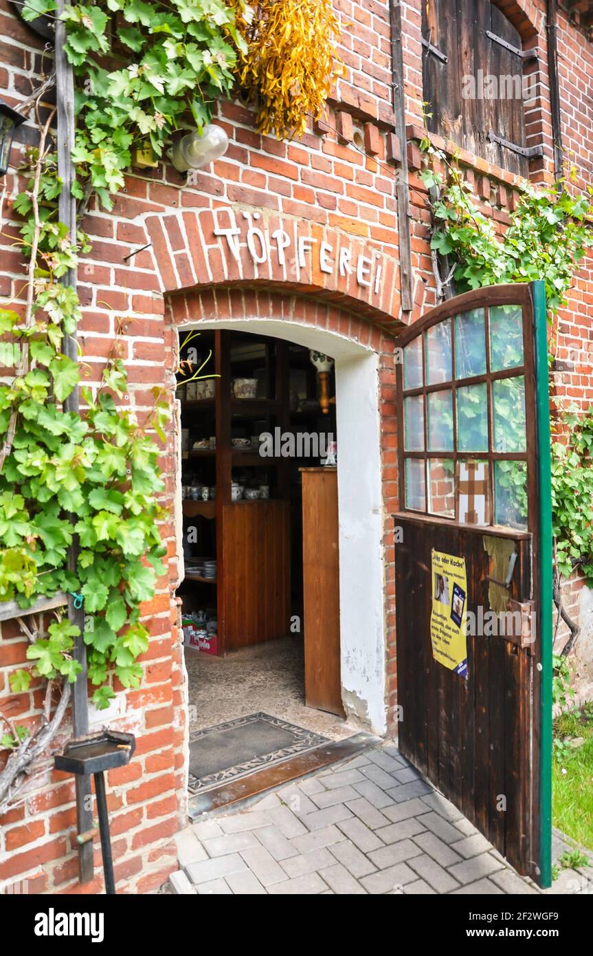Entrance to an old traditional pottery. The building is clinker brick and overgrown with grapevines. Stock Photo