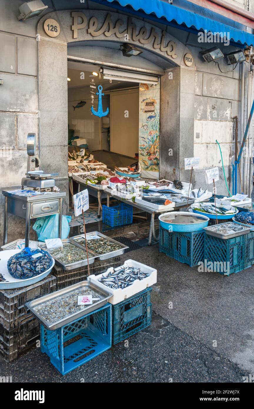 View of the display of a fish shop. The goods are also presented on the street on boxes and tables Stock Photo