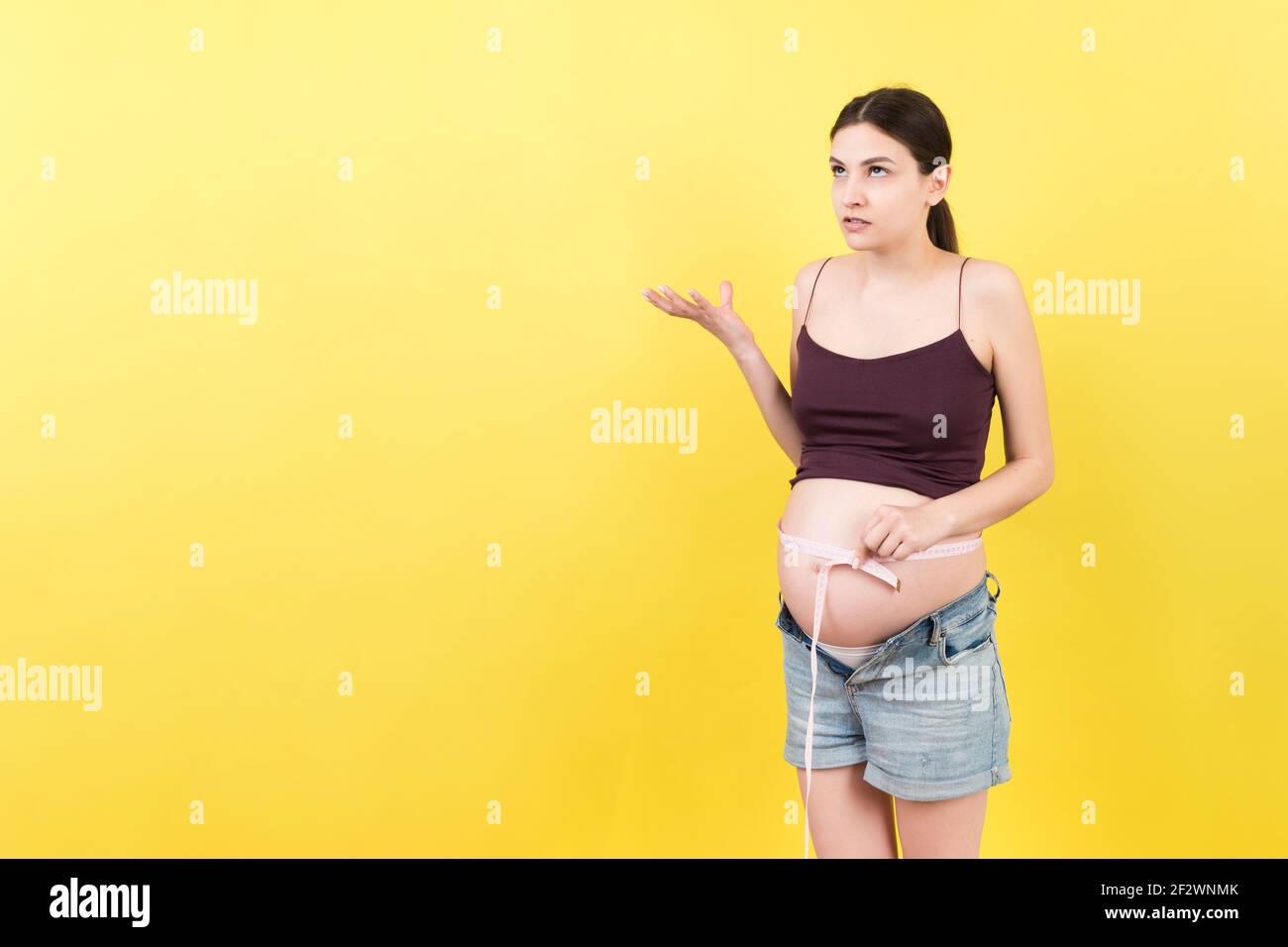 pregnant woman using tape measure to check baby development and the