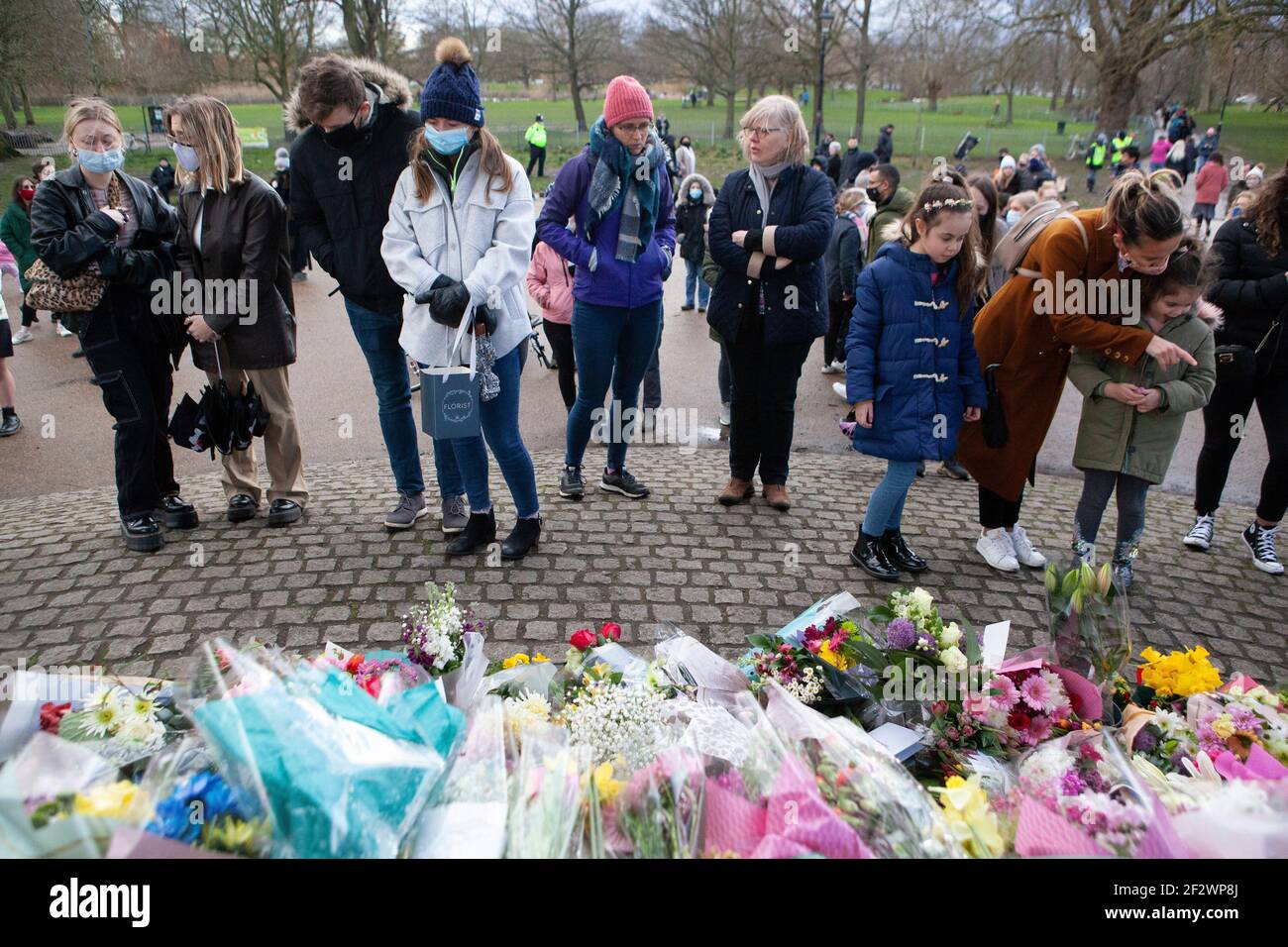 London, UK, 13 March 2021: A memorial of flowers for Sarah Everard draws hundreds of well wishers at Clapham Common bandstand. Tributes included plants, flowers, candles and messages such as 'When Will Women be Safe?' and 'She was only walking home.' An official vigil has been cancelled due to police concerns over coronavirus. Anna Watson/Alamy Live News Stock Photo