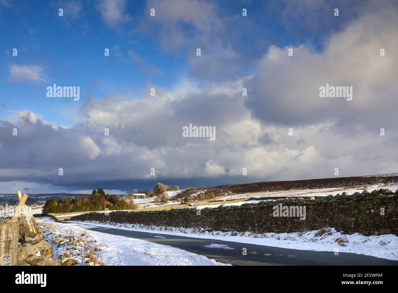 Late afternoon, and storm clouds begin to gather over the moorland single tracked road in Yorkshire Stock Photo