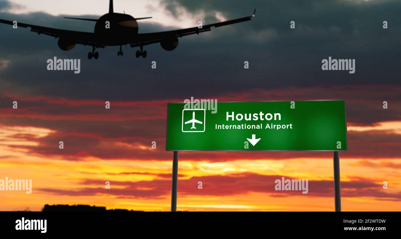 Airplane silhouette landing in Houston, Texas, USA, United States. City arrival with airport direction signboard and sunset in background. Trip and tr Stock Photo