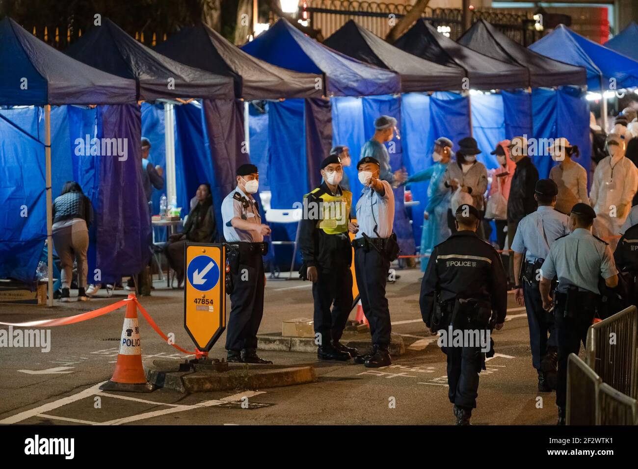 Hong Kong, China. 13th Mar, 2021. Police officers stand guard in the lockdown zone.The Hong Kong government has decided to lock down a section of Robinson Road in the Mid-Level district of Hong Kong in a bid to control the Covid-19 coronavirus from spreading. Residents in the locked down zone have to take a compulsory Covid-19 test and they will only be allowed to leave the zone after their test result return negative. (Photo by Geovien So/SOPA Images/Sipa USA) Credit: Sipa USA/Alamy Live News Stock Photo