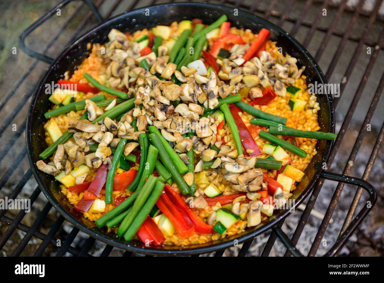 Paella being prepared on improvised stove Stock Photo Alamy