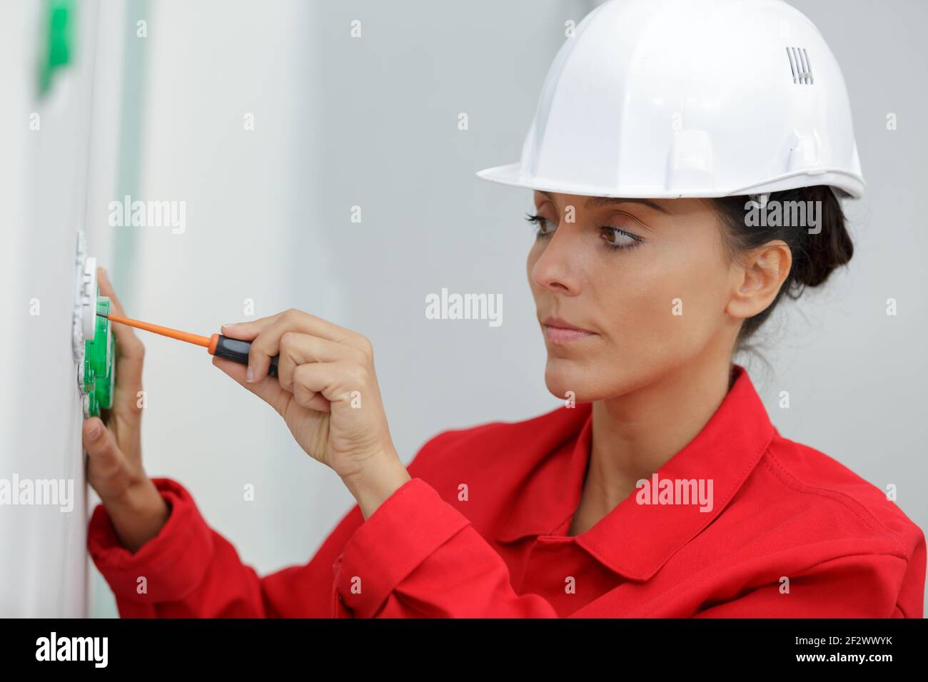 female electrician fixing socket electricity problem Stock Photo