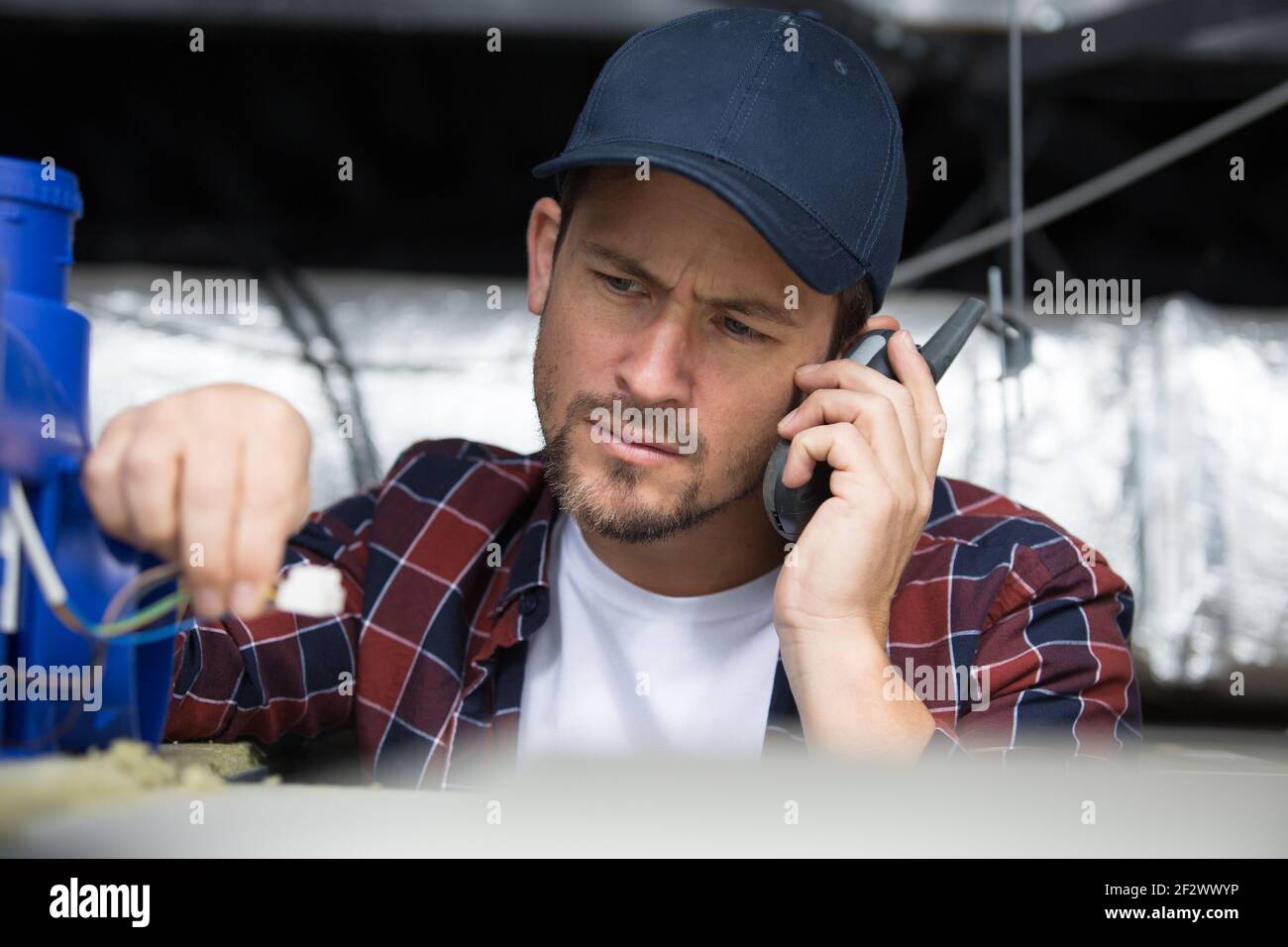 electrician installing ventilation in ceiling Stock Photo