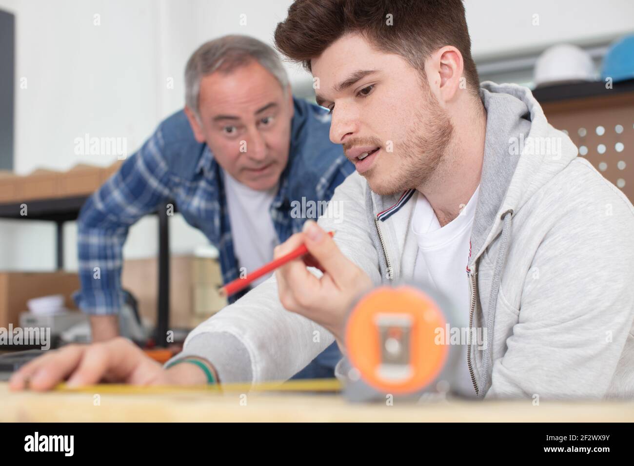 carpenter with apprentice in training period Stock Photo