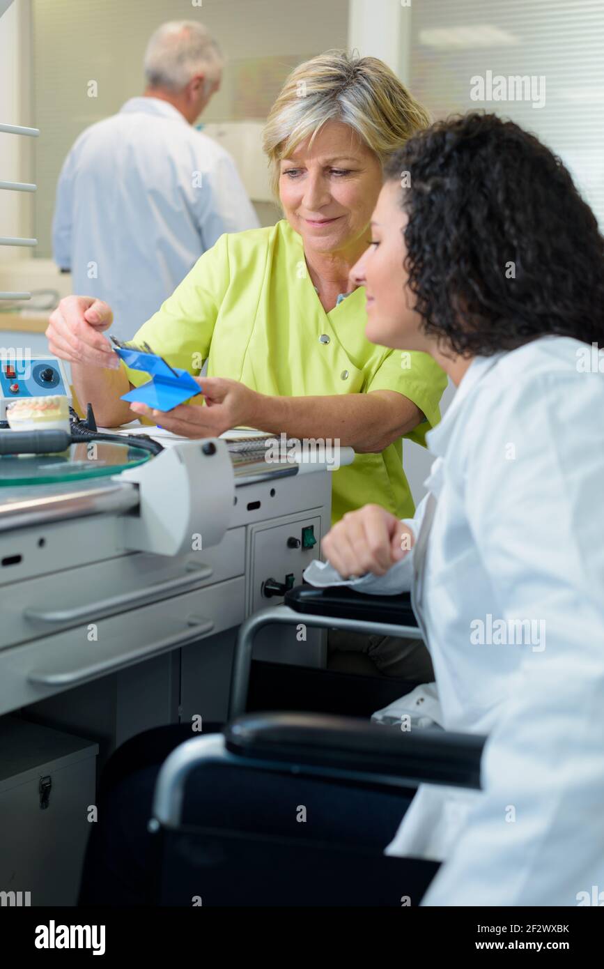 woman training disabled trainee in medical lab Stock Photo