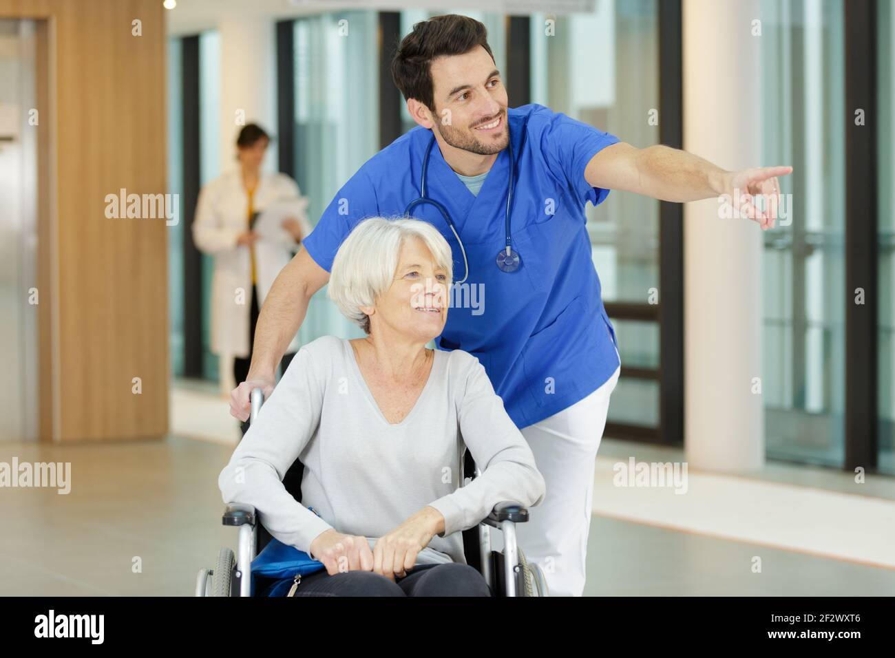 nurse pushing an old woman in a wheelchair Stock Photo - Alamy