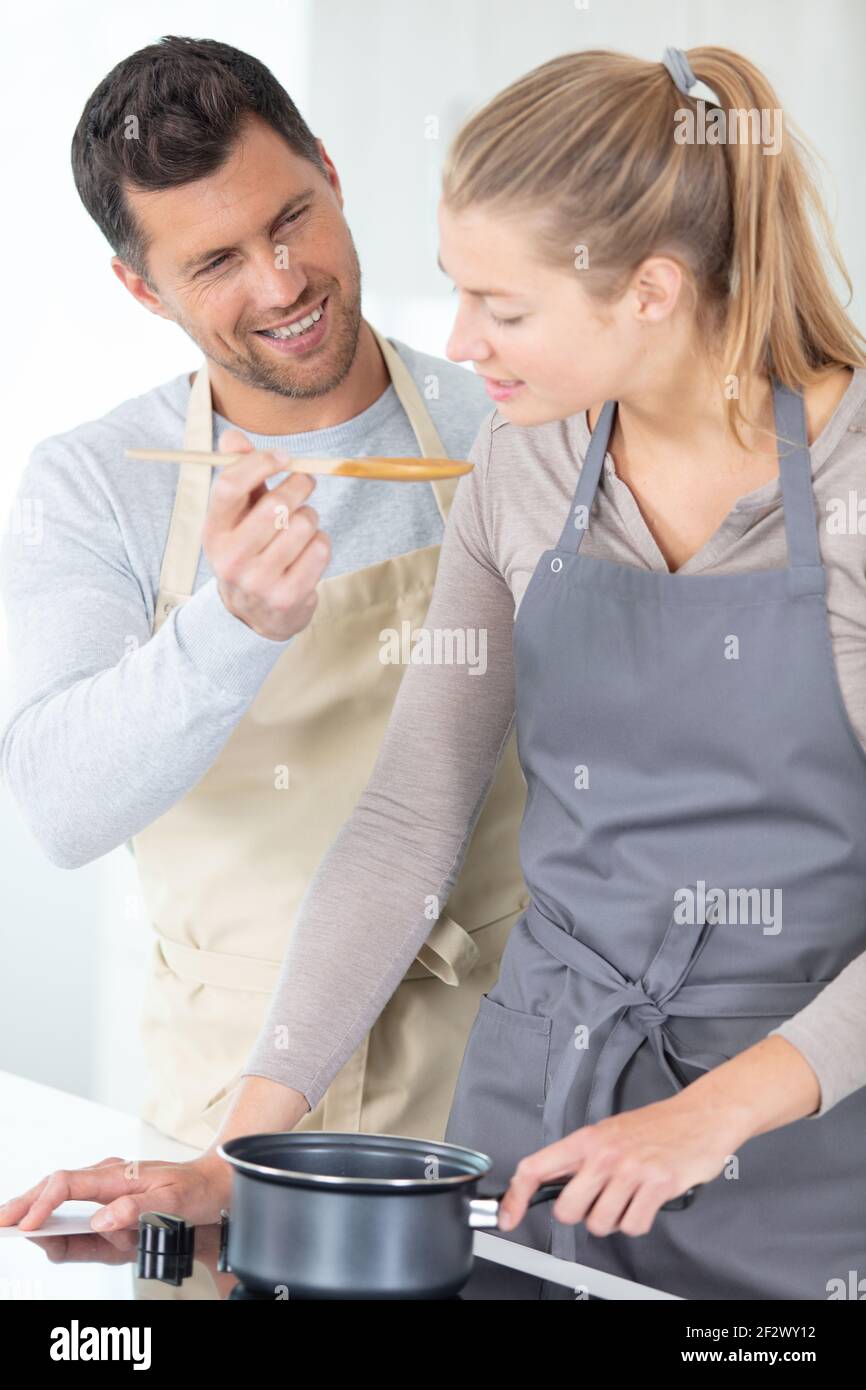 couple making pizza in kitchen together Stock Photo